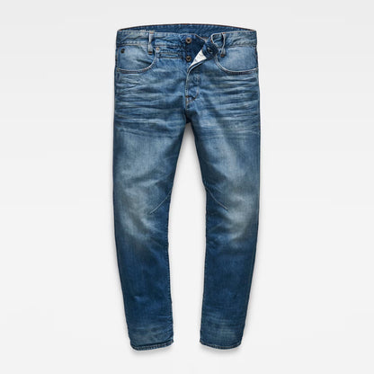 Front view of tapered blue jeans in medium wash with a 5-pocket design on a white background.