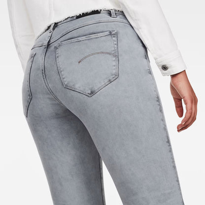 Detail close-up of light blue skinny jeans highlighting the back pockets and high waist.