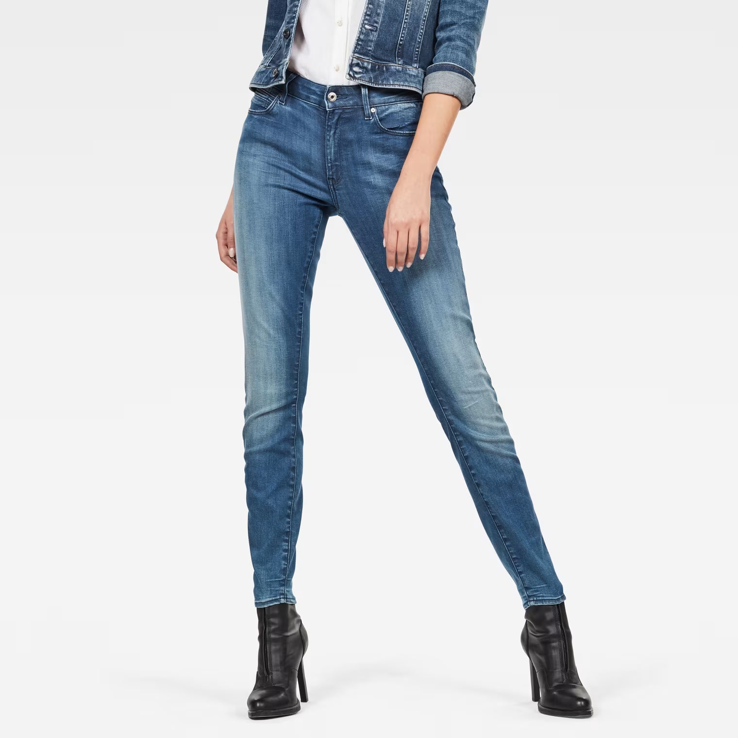 Lifestyle shot of medium blue skinny jeans featuring a fitted design and high waist.