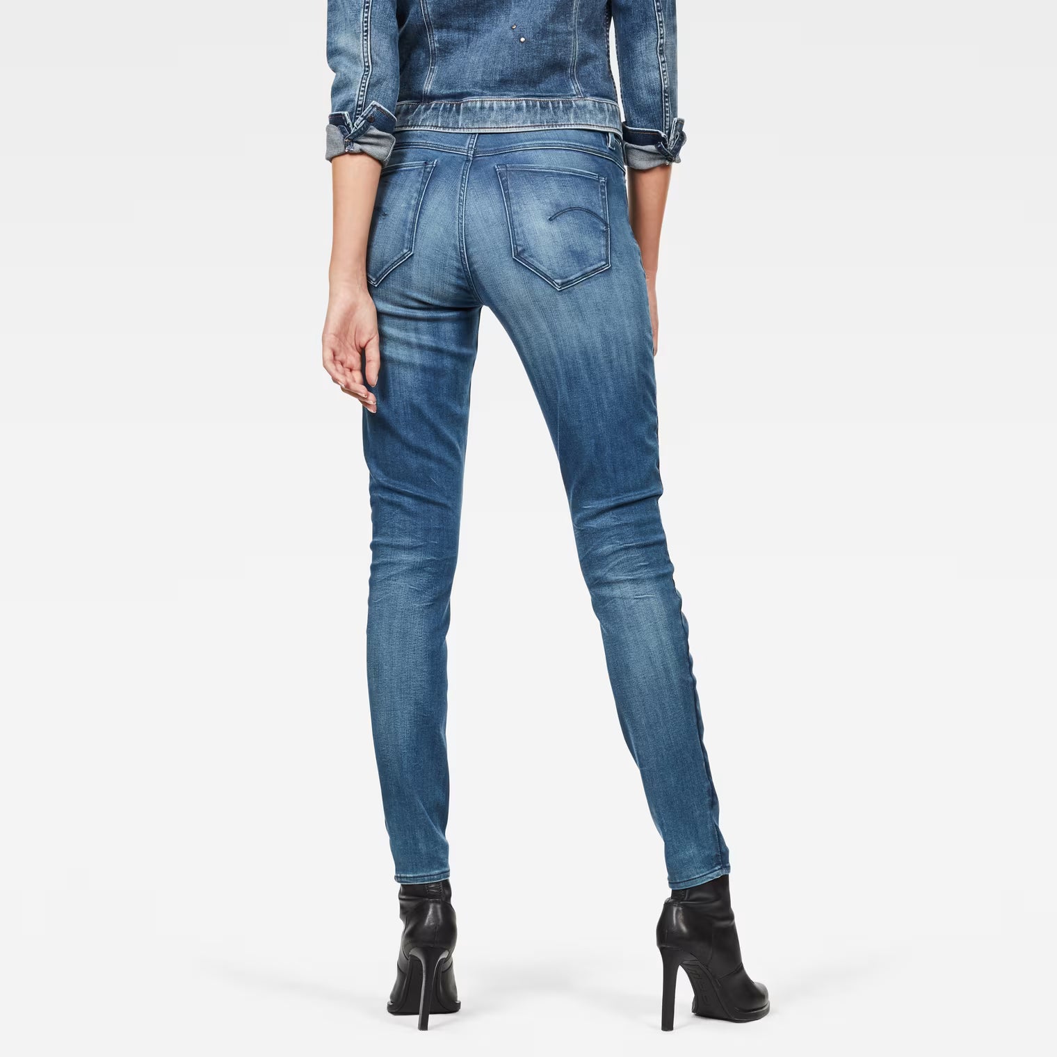 Back view of medium blue skinny jeans showcasing a fitted design and high waist.