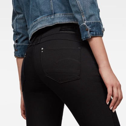 Detail close-up of the back pocket on black skinny jeans with a skinny fit.