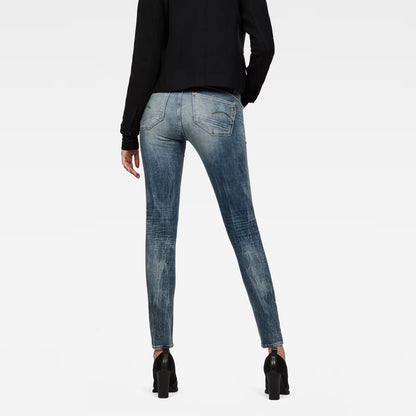 Back view of light blue skinny jeans featuring a mid waist on a white background