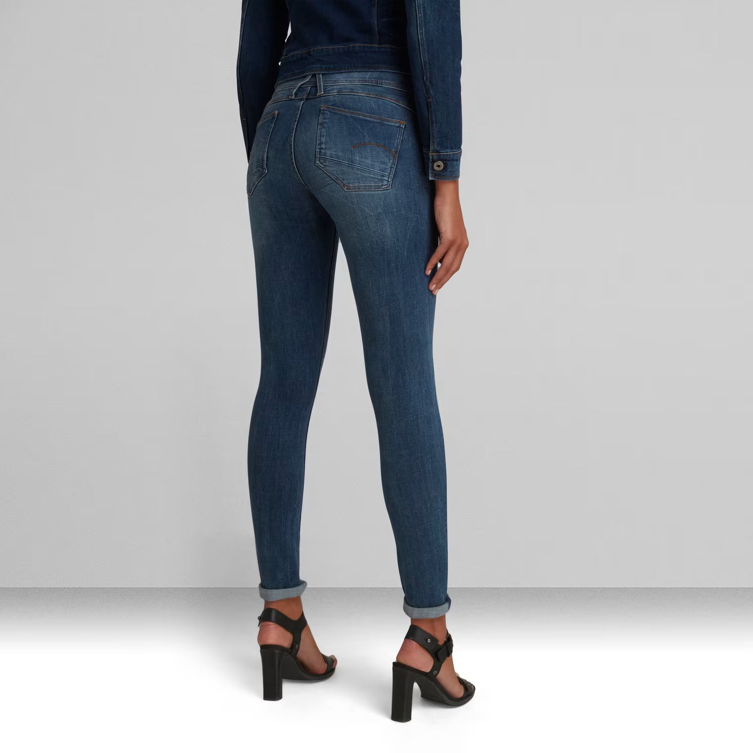 Back view of dark blue skinny jeans with back pockets and a super skinny fit.