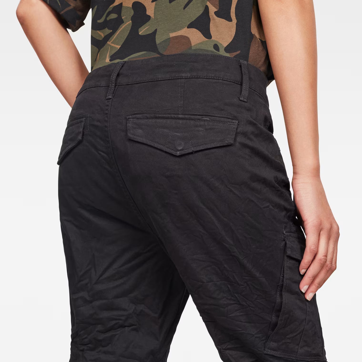 Detail close-up of the black skinny cargo pants highlighting the mid waist and cargo pockets.