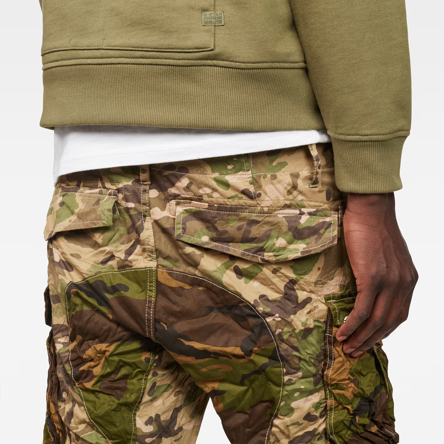 Close-up detail of the back of beige tapered pants highlighting pocket details