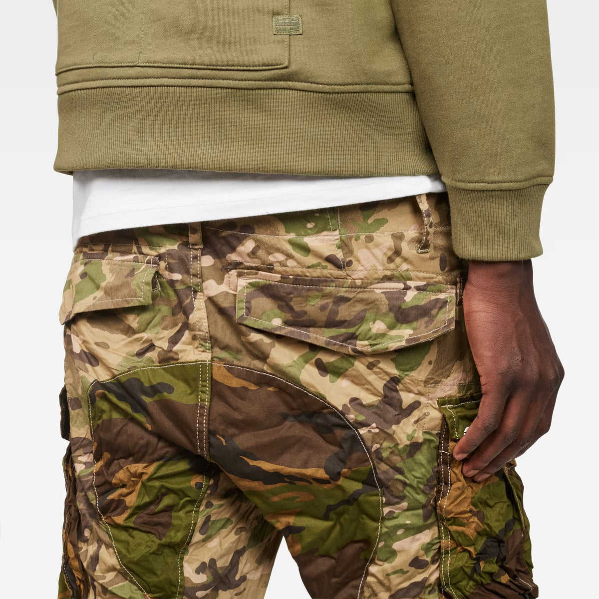 Close-up detail of the back of beige tapered pants highlighting pocket details