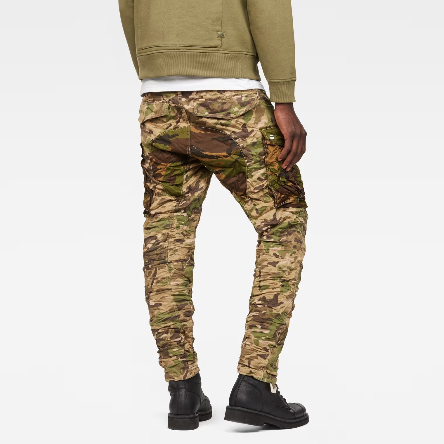 Back view of beige tapered pants featuring pocket details on a white background