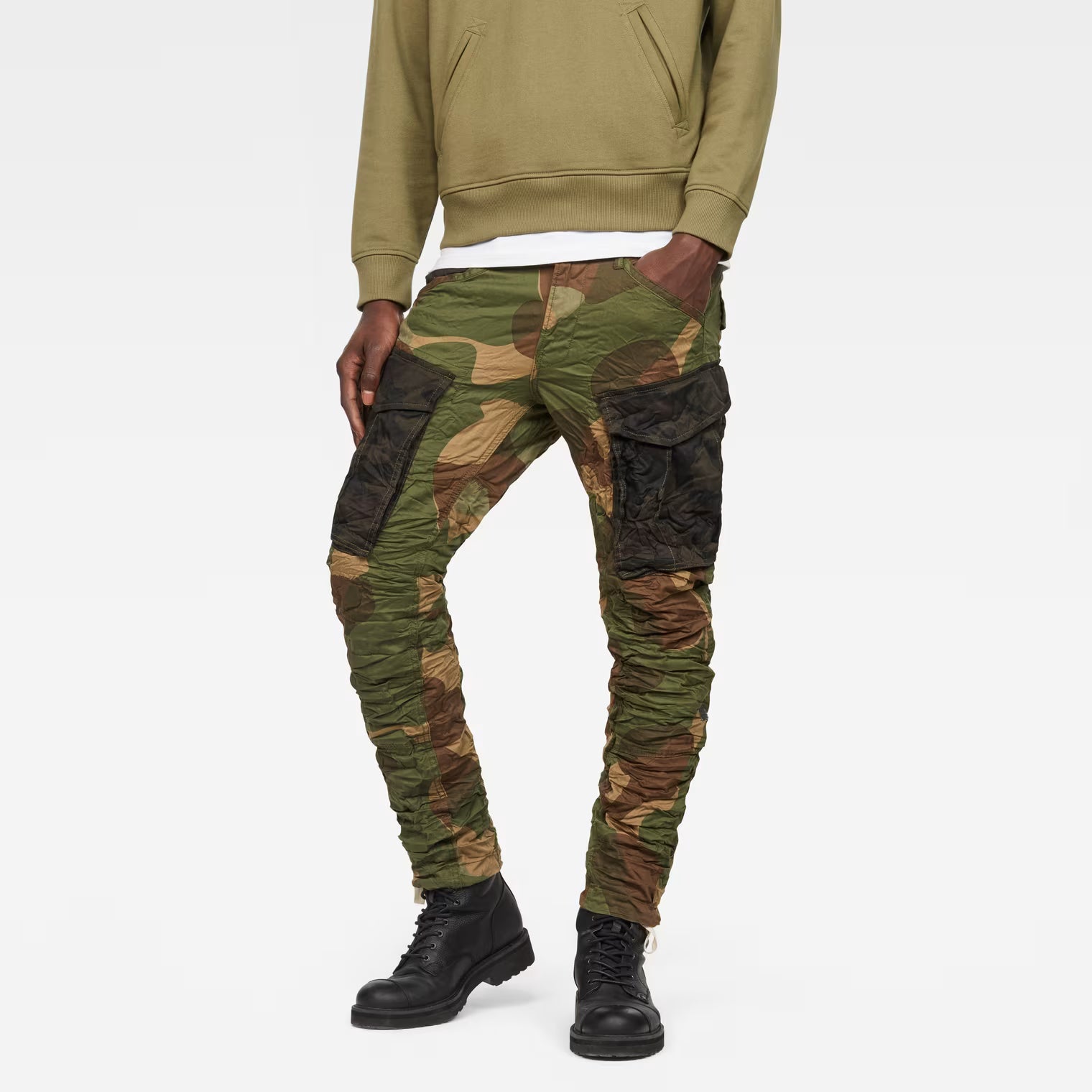 Front view of the green tapered pants featuring a camouflage pattern and cargo pockets.