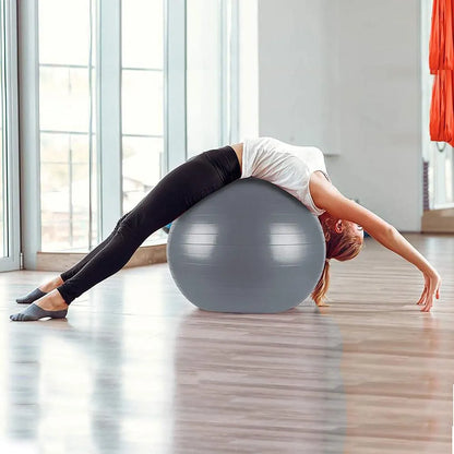 Woman stretching backwards over grey Liveup gym ball in studio
