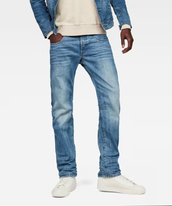 Lifestyle shot of a model wearing blue G-STAR RAW 3301 straight jeans in a casual setting.
