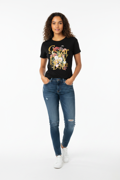 Woman in black G-Star Raw floral graphic T-shirt with ripped blue jeans, full-length view